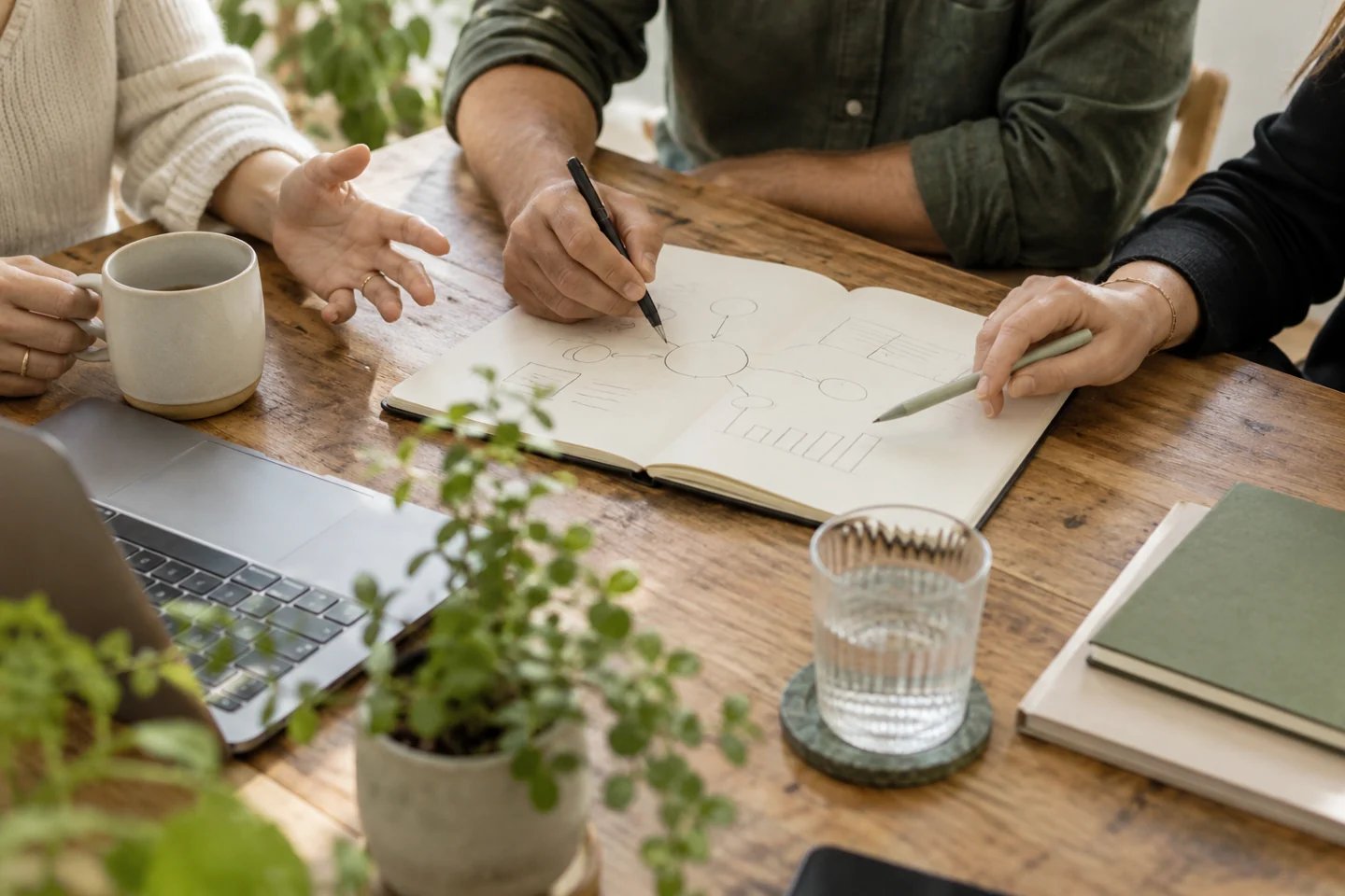 Conceptual image of colleagues sketching ideas together around a table